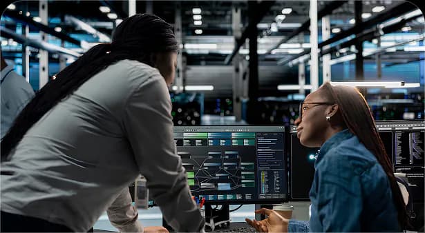 Engineers working together at monitoring screens in a datacenter
